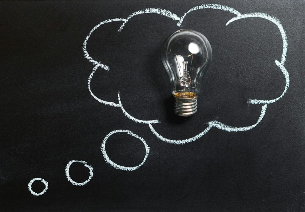 Light bulb inside chalk-drawn thought bubble symbolizing creativity and problem-solving, featured in Evenflow blog "Design Thinking and Design Activating: What’s the Difference?"